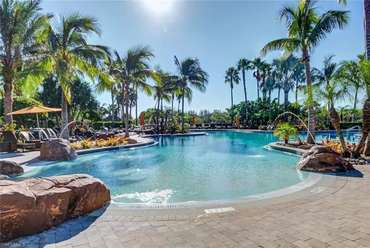 Paseo community pool surrounded by palms, sun loungers and fountains